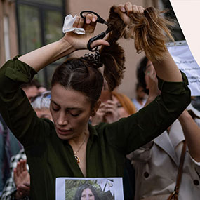 An Iranian woman cutting her hair in protest of the death of Mahsa Amini